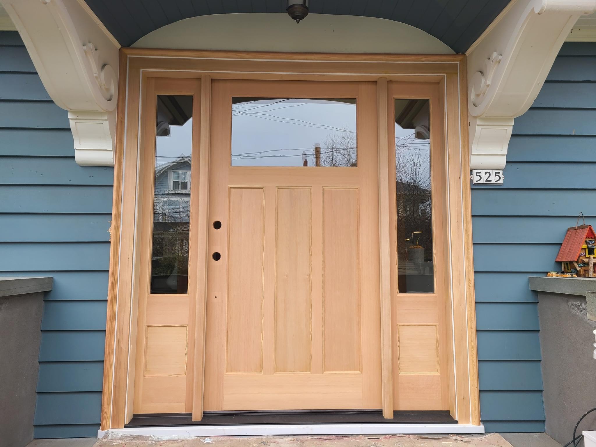 Before — raw unfinished fir entry door with sidelights